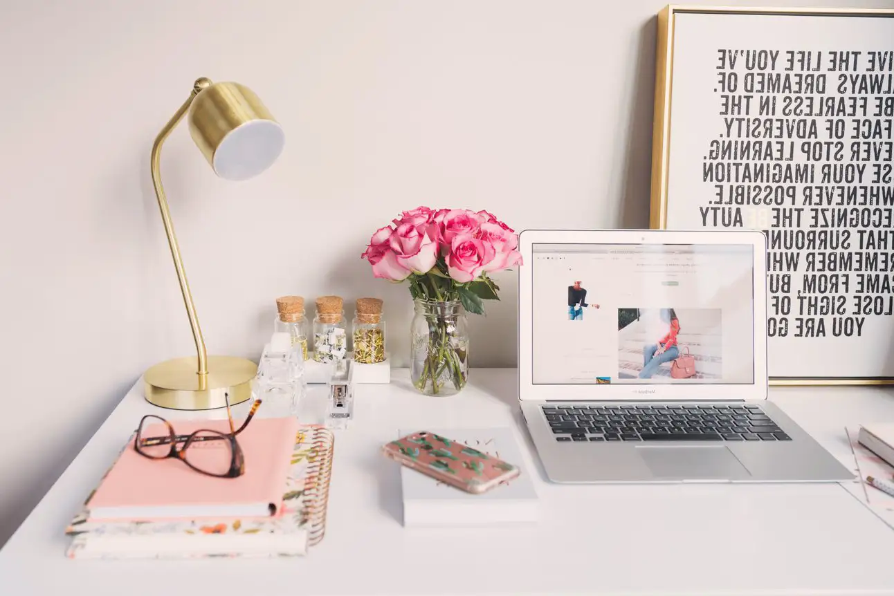 Mettre en ligne un site web attractif avec des mots clés pertinents pour une image de MacBook Air, lampe d'étude dorée et livres en spirale.